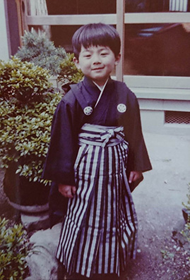 The childhood picture of Dr. MIZUNO wearing Hakama and standing at backyard