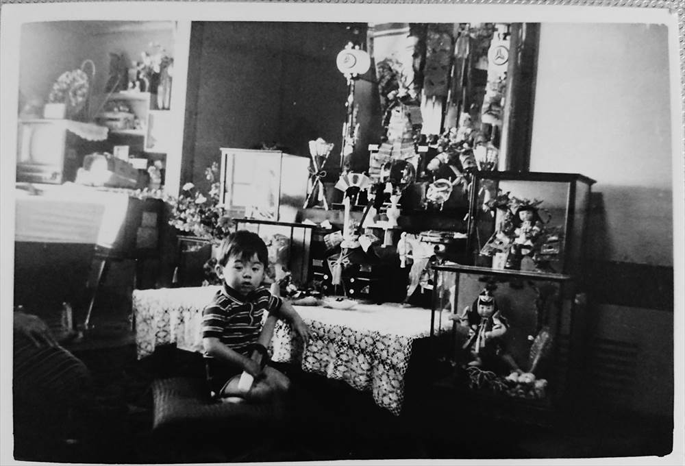 The picture of Dr. MIZUNO sitting in front of Japanese Boy's Festival decorations and dolls in his childhood