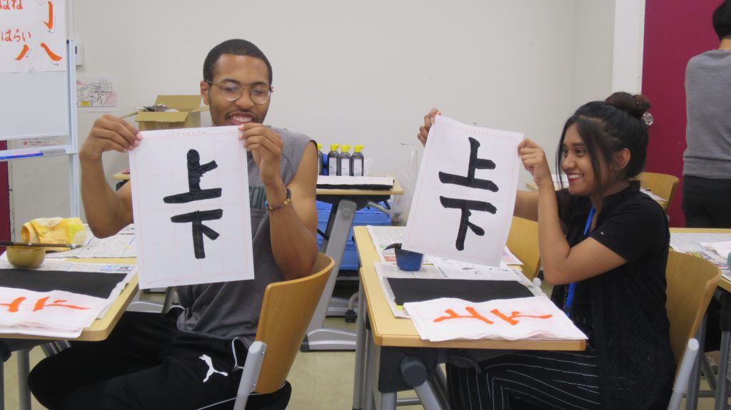 書道のクラスで書いた漢字を披露する留学生