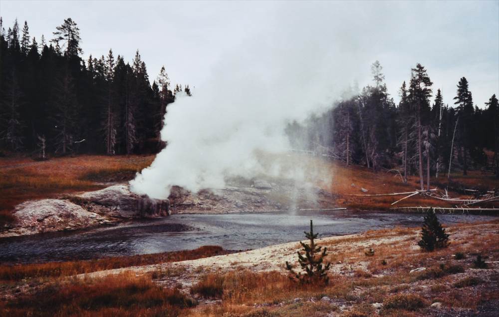 川辺で蒸気を噴き出すリバーサイドガイザーの写真