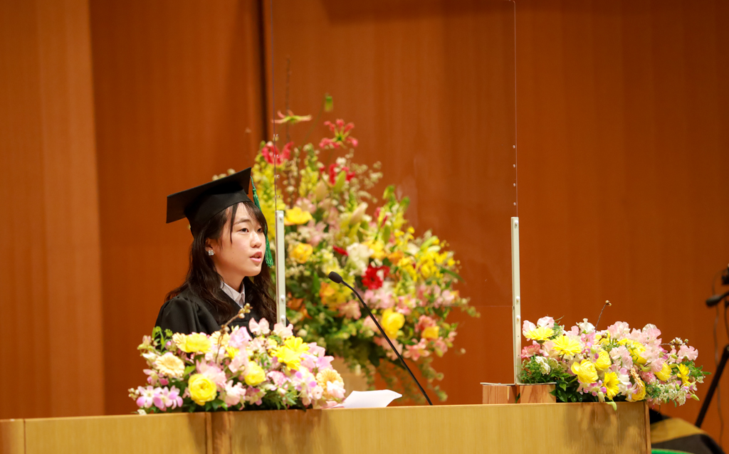 卒業生代表の元木さんが壇上でスピーチしている写真