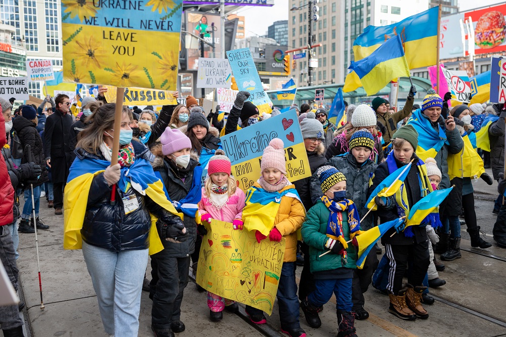 ウクライナ侵攻に反対する大規模なデモ行進に参加するトロント市民の写真