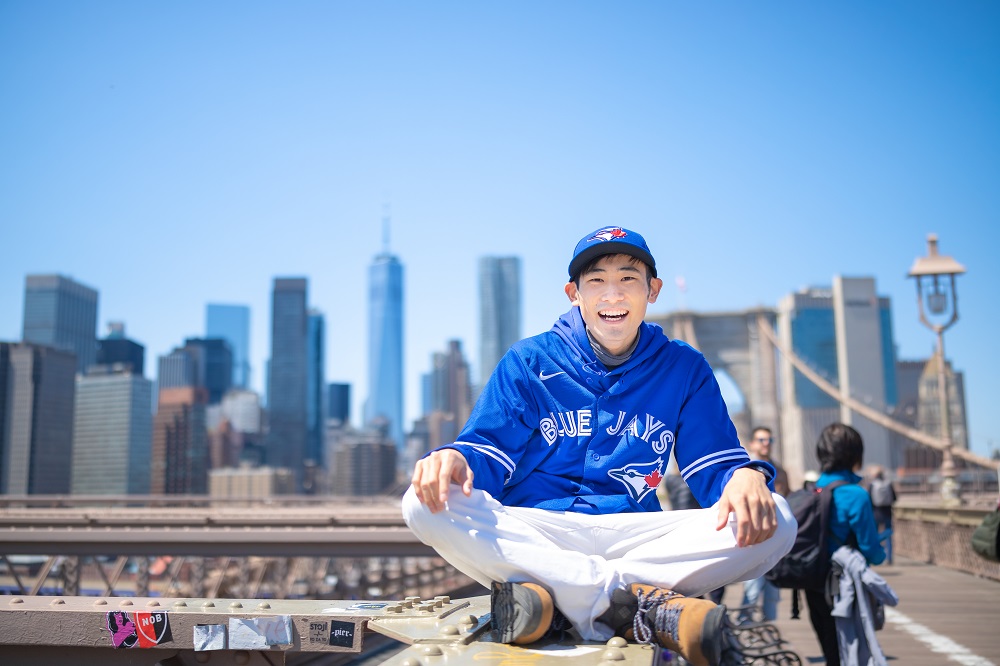 NYのブルックリン橋の上に座る中尾さんの写真