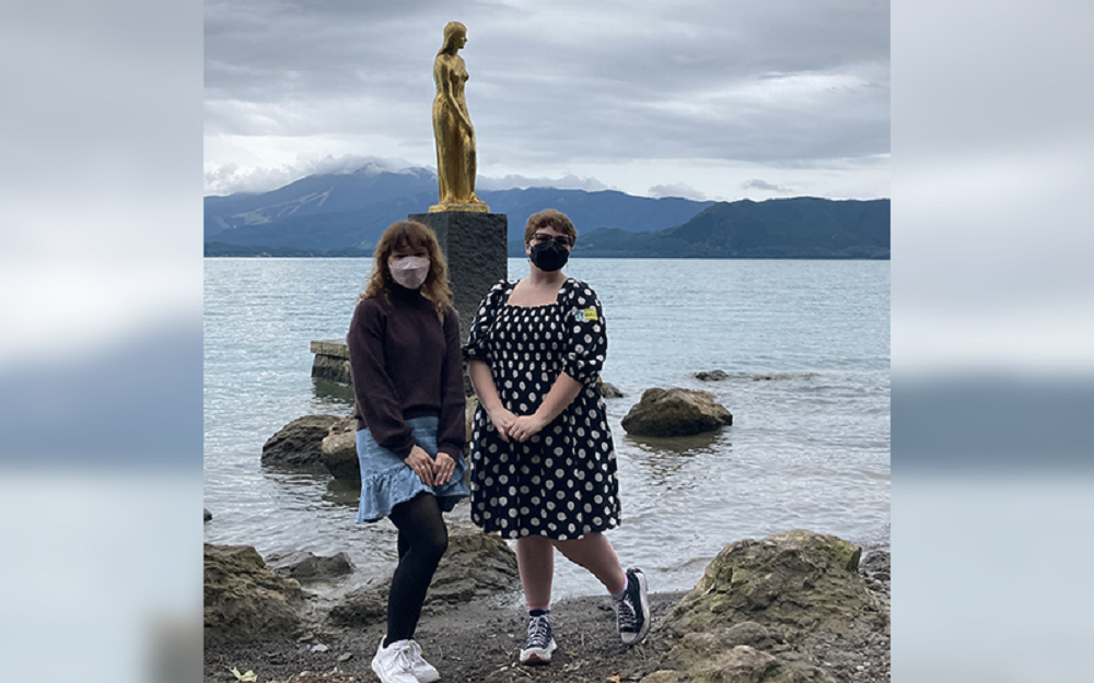 田沢湖たつこ像前にて学生2名の写真