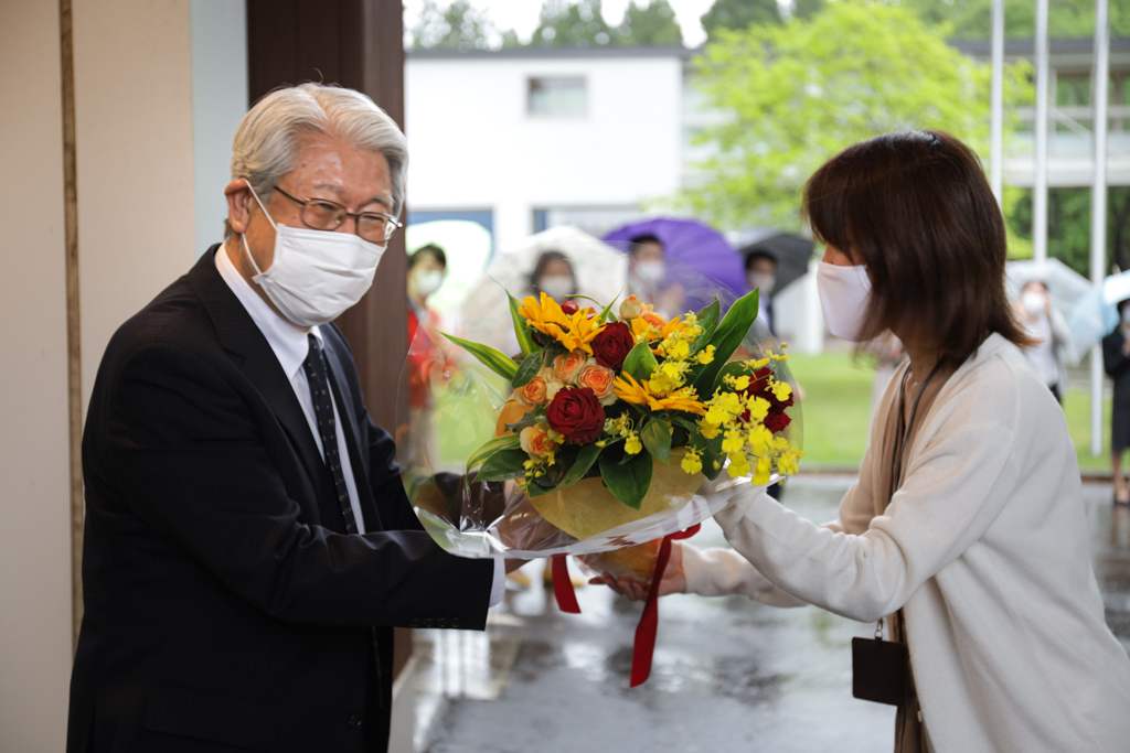 Picture of the President SUZUKI being handed the bouquet by his secretary