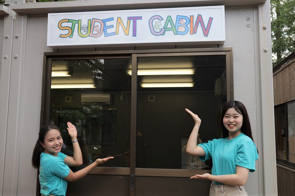 Student Cabinの建物を紹介する学生2名の写真
