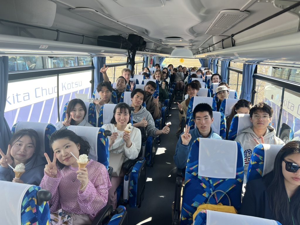 バスの中でソフトクリームを食べる学生たち