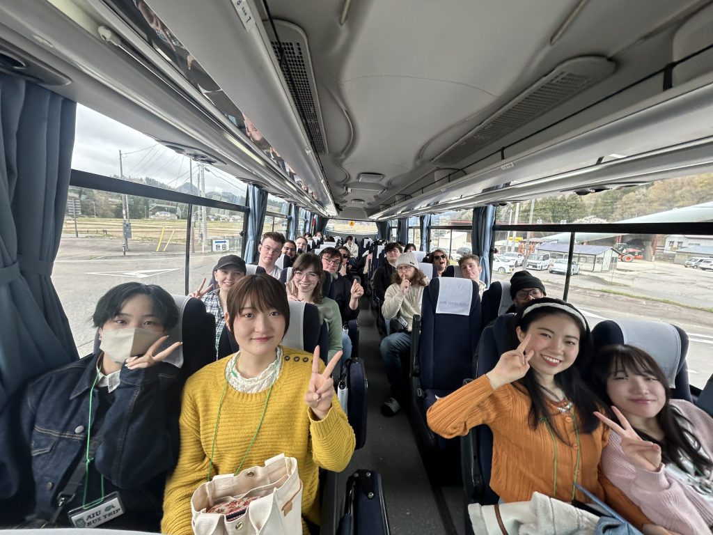 バスの中で和やかな笑顔で映る学生たちの写真
