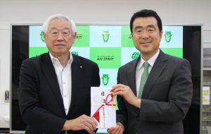 三浦会長から磯貝常務理事へ目録贈呈