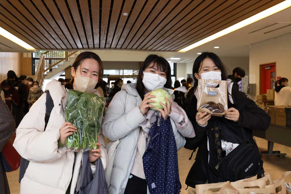 配布された野菜を持った学生の写真
