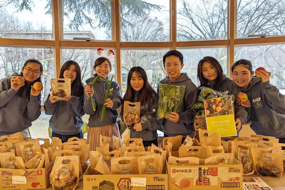 配布した生鮮食品を持った学生ボランティアの集合写真