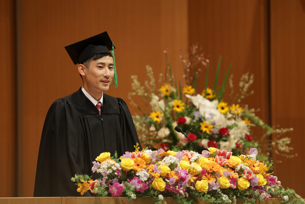 卒業生代表の中尾さんが壇上でスピーチしている写真